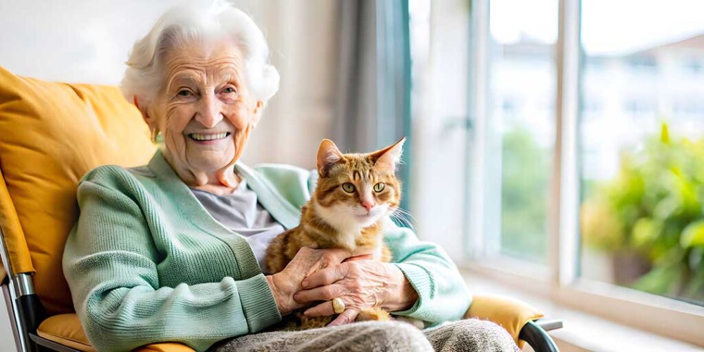Volunteer and assisted living resident playing a board game together in a bright community room.